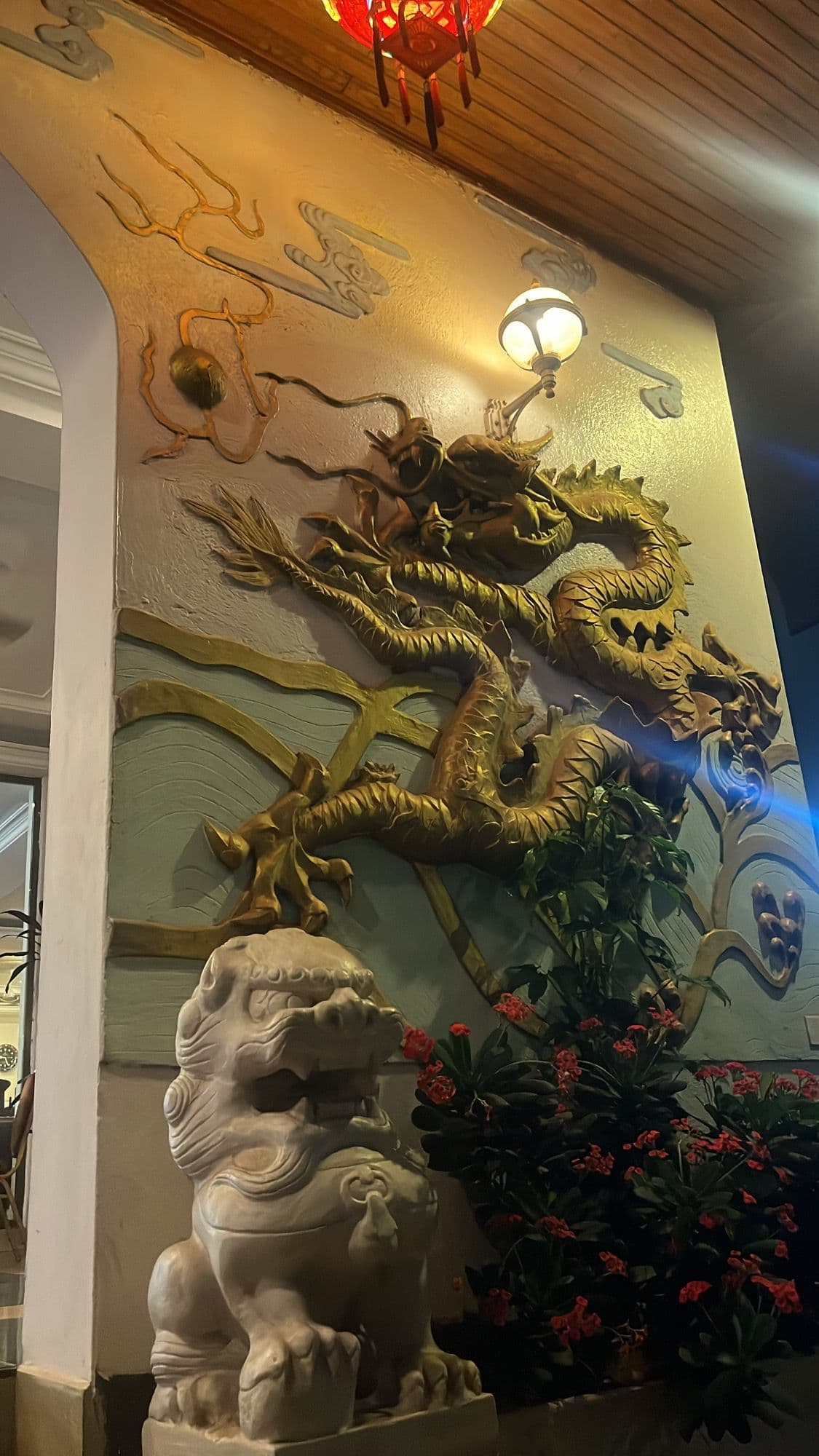 Carved golden dragon and stone lion at the entrance