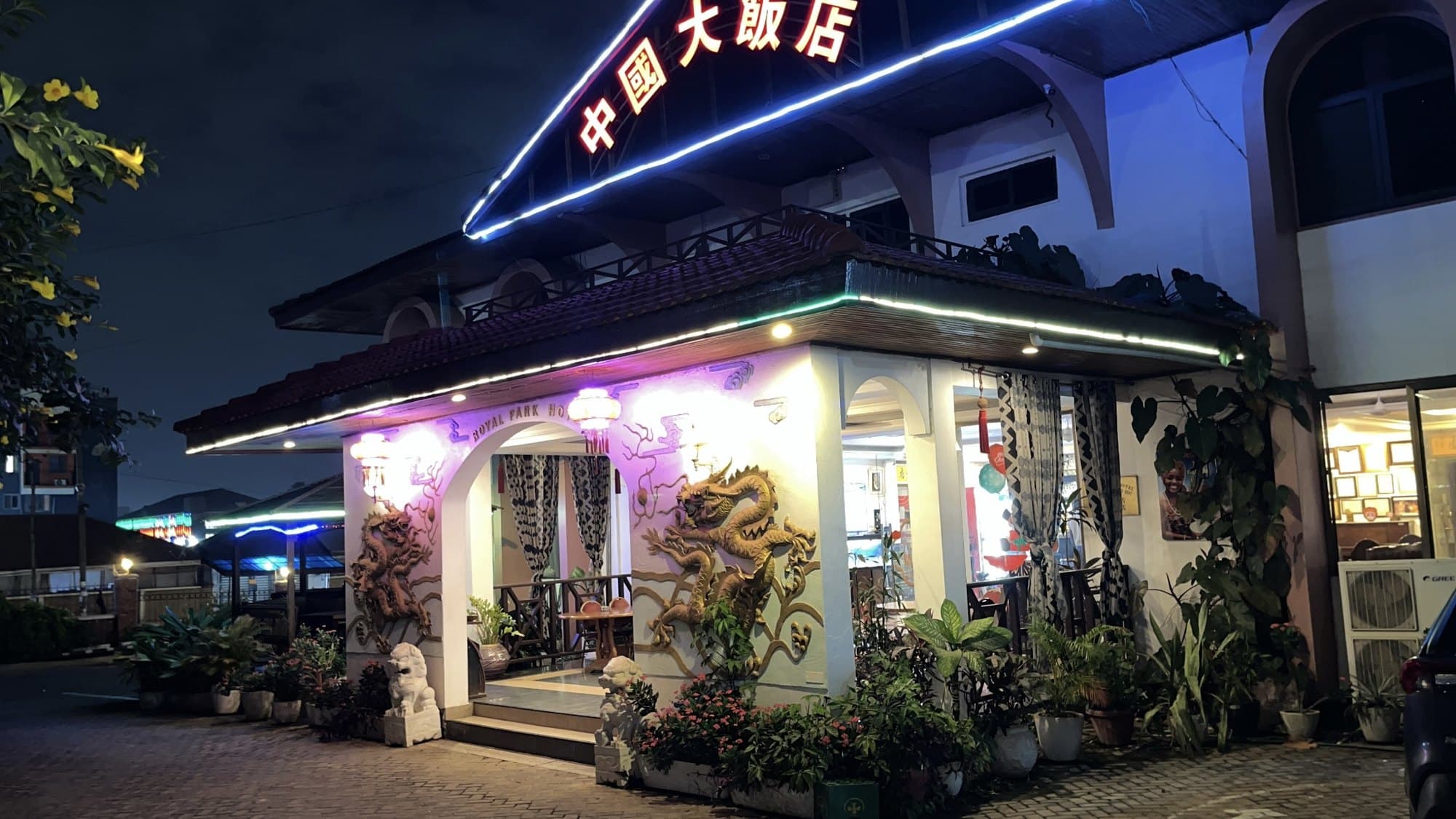 Royal Park's entrance at night, with carved dragons, stone lions and lanterns